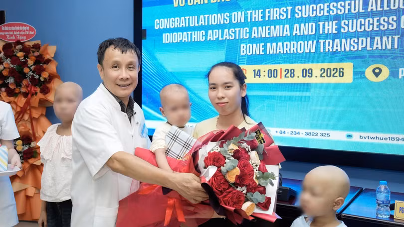 GS Phạm Như Hiệp, Giám đốc Bệnh viện TƯ Huế tặng quà và hoa cho bé gái 4 tuổi suy tủy nhận nguồn cho từ em trai 18 tháng tuổi và ghép tủy thành công. Ảnh Nguyễn Lê.