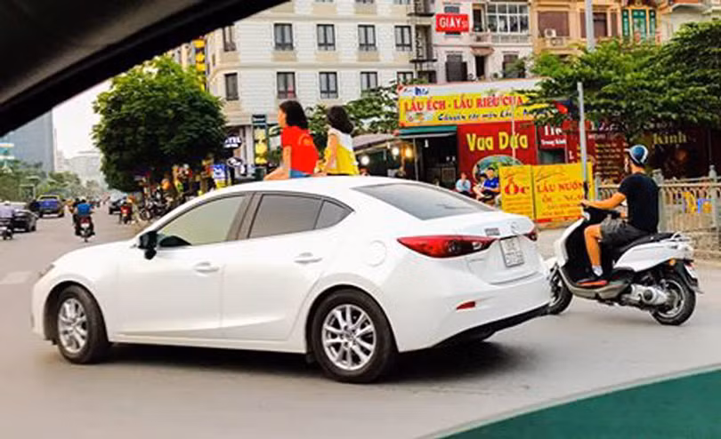 Nhiều phụ huynh cho phép con mở cửa sổ trời và thò đầu lên khi xe đang chạy, thậm chí cho ngồi hẳn lên cửa sổ trời để hóng gió, ngắm trời đất. (Ảnh: Dân trí) Nhiều phụ huynh cho phép con mở cửa sổ trời và thò đầu lên khi xe đang chạy, thậm chí cho ngồi hẳn lên cửa sổ trời để hóng gió, ngắm trời đất. (Ảnh: Dân trí)