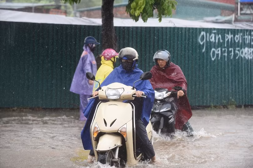 Không nên mặc áo mưa cánh dơi phủ tà áo lên trước đèn xe máy khi trời mưa bão. Ảnh ST Không nên mặc áo mưa cánh dơi phủ tà áo lên trước đèn xe máy khi trời mưa bão. Ảnh ST