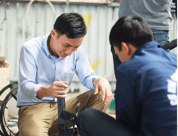 Nông dân trẻ Tạ Đình Huy (bên trái) - tác giả của nhiều máy nông nghiệp có giá trị. Ảnh: VietnamNet