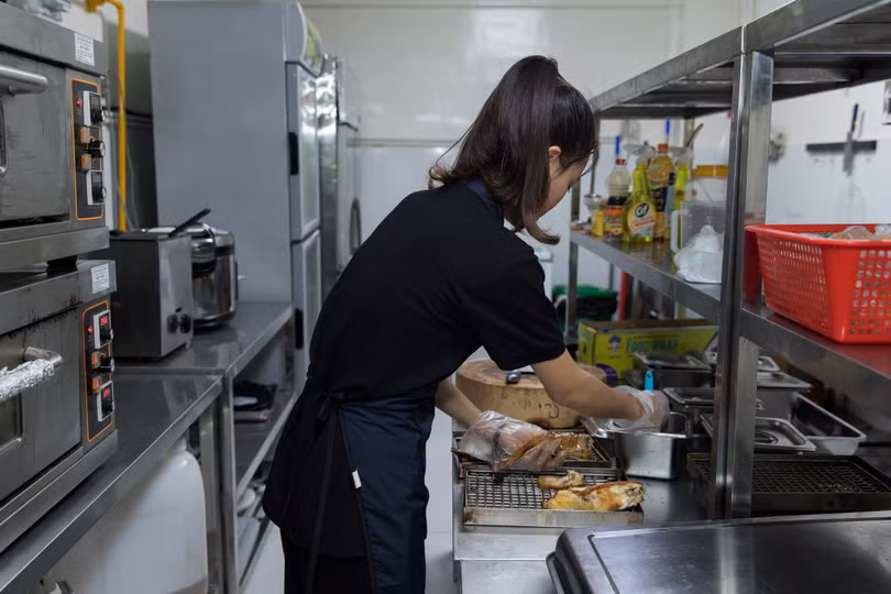Một nhân viên nhà hàng đang chế biến đồ ăn tại Grab Kitchen Một nhân viên nhà hàng đang chế biến đồ ăn tại Grab Kitchen