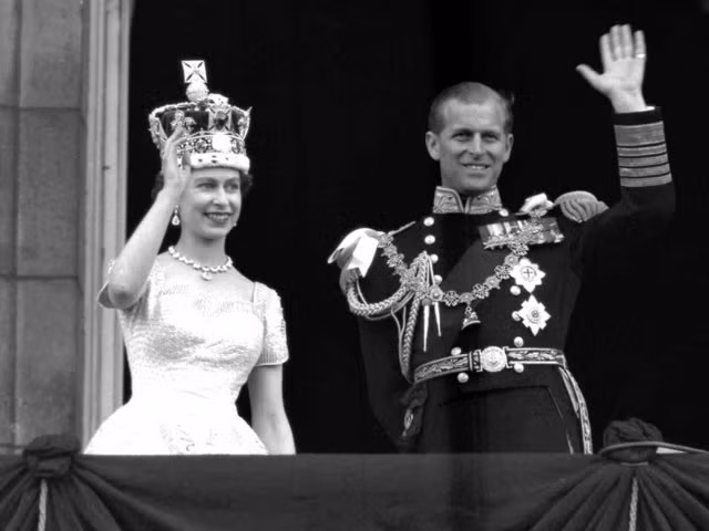 Nữ hoàng Elizabeth II và hoàng thân Philip, Công tước xứ Edinburgh, vẫy tay chào người dân từ ban công Cung điện Buckingham, sau khi bà đăng quang ngày 2/6/1953 (Ảnh AP)
