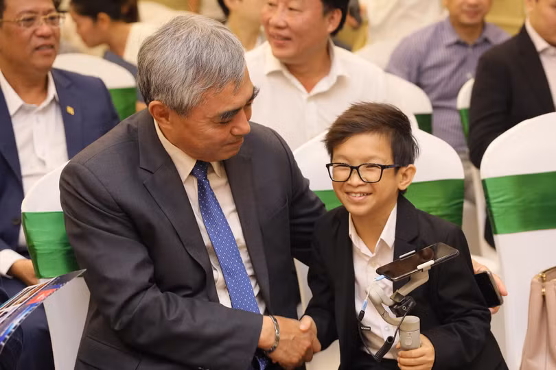 Ông Nguyễn Minh Hồng - Chủ tịch Hội Truyền thông số Việt Nam - trò chuyện với "thầy giáo tí hon" Nguyễn Văn Hùng - một thành viên Công ty Cổ phần NLS-DNXH