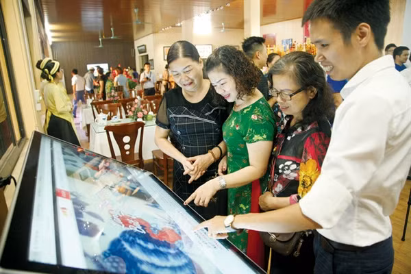 Du khách trải nghiệm ứng dụng du lịch thông minh tại Trung tâm thông tin du lịch Bát Tràng (Hà Nội)