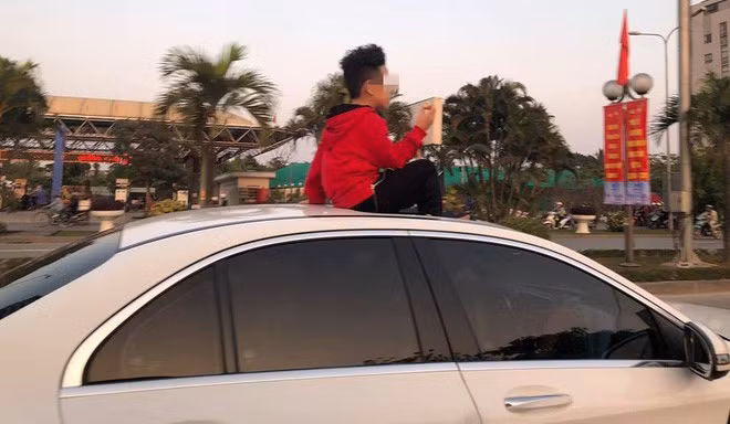 Em bé ngồi trên cửa sổ trời ô tô khiến nhiều người thảng thốt. (Ảnh: Thế giới trẻ) 