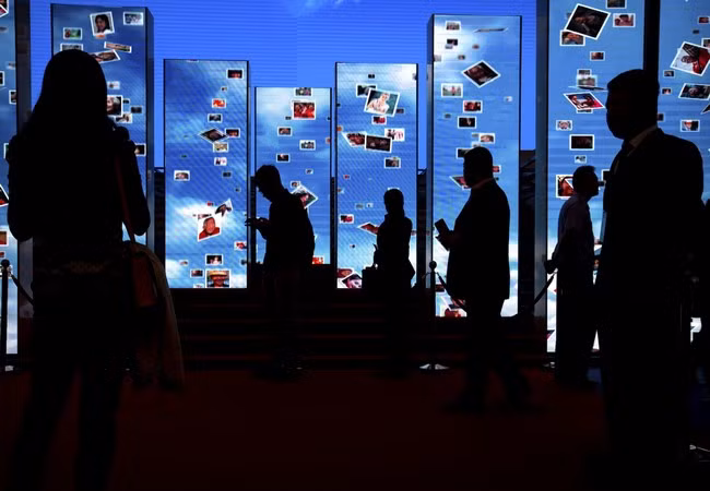 Khách tham quan bước qua các màn hình video tại một triển lãm trưng bày các thành tựu của Trung Quốc đạt được sau 5 năm dưới sự lãnh đạo của chủ tịch Trung Quốc Tập Cận Bình tại Trung tâm Triển lãm Bắc Kinh, Trung Quốc ngày 28.09.2017 (ảnh AP)