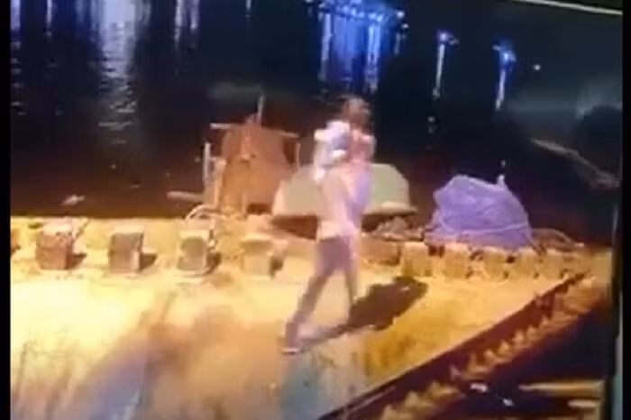 Trần Văn Viên bế con ra sông Trường Giang (Ảnh cắt từ clip lan truyền trên mạng xã hội)