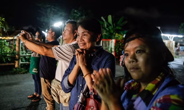 Người dân Thái cầu nguyện và vui mừng khi nhìn thấy những chiếc xe cứu thương chở các cậu bé trên đường tới bệnh viện Người dân Thái cầu nguyện và vui mừng khi nhìn thấy những chiếc xe cứu thương chở các cậu bé trên đường tới bệnh viện