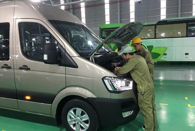 Các công nhân Thaco đang kiểm tra kỹ thuật xe buýt nhỏ Ảnh: Tuấn Nguyễn