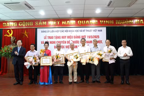 TSKH. Phan Xuân Dũng – Bí thư Đảng ủy, Chủ tịch Liên hiệp Hội Việt Nam (ngoài cùng bên trái) và PGS.TS Phạm Ngọc Linh – Phó Bí thư thường trực, Phó Chủ tịch Liên hiệp Hội Việt Nam (ngoài cùng bên phải) trao huy hiệu cho các đảng viên.