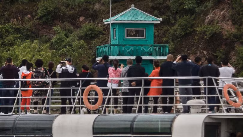 Du khách Trung Quốc trên thuyền tham quan dọc sông Yalu, chia cắt thành phố Đan Đông của Trung Quốc và Sinuiju của Triều Tiên tháng 5/2017. Ảnh: Getty 