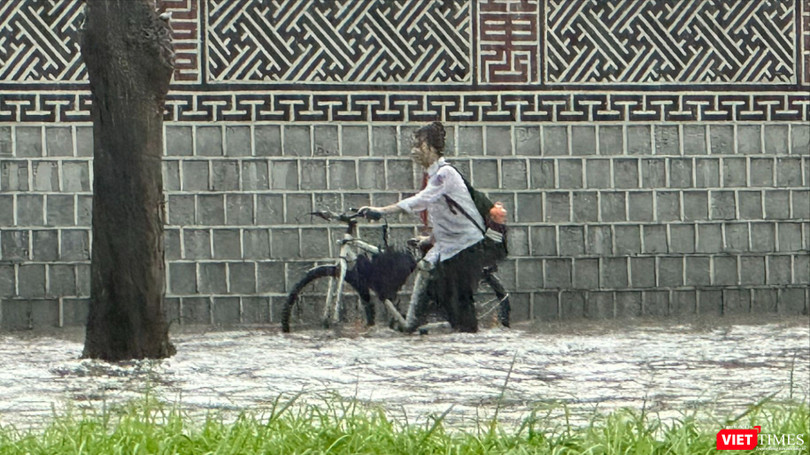 Một nữ sinh ướt hết quần áo khi di chuyển trên tuyến đường ngập sâu ở Hà Nội.
