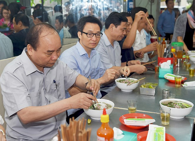 Thủ tướng và đoàn kiểm tra dừng chân, dùng điểm tâm tại một quán ăn đường phố thuộc phường Tân Thành, TPHCM. Ảnh: VGP/Quang Hiếu. 