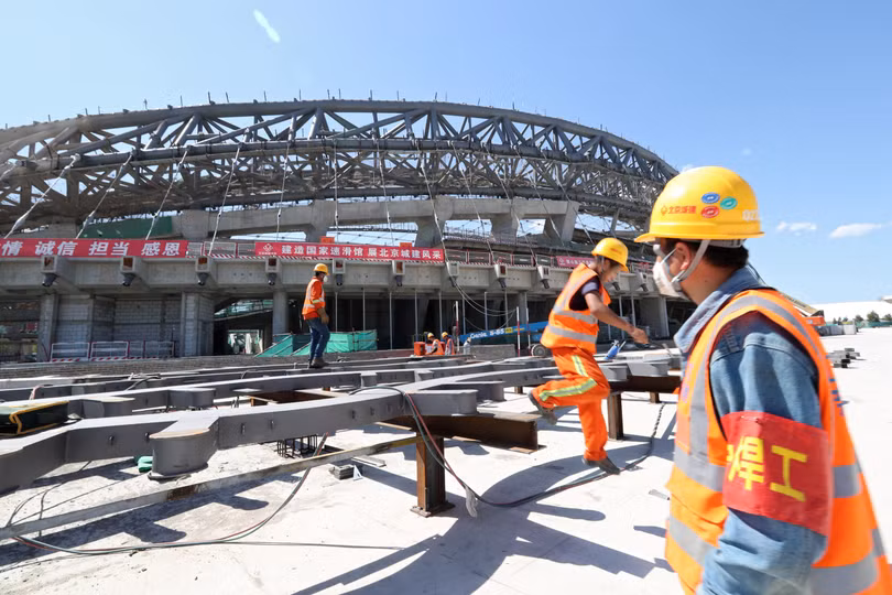 Công nhân xây dựng một sân trượt băng tốc độ cho Thế vận hội mùa đông 2022 ở Bắc Kinh. Trung Quốc đã tăng cường xây dựng cơ sở hạ tầng trong năm nay theo một chương trình kích thích kinh tế (ảnh Reuters)