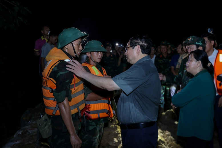 Thủ tướng động viên các lực lượng chức năng đang ứng phó với mưa lũ tại các xã Trung Giã, Đa Phúc. Ảnh: VGP/Nhật Bắc