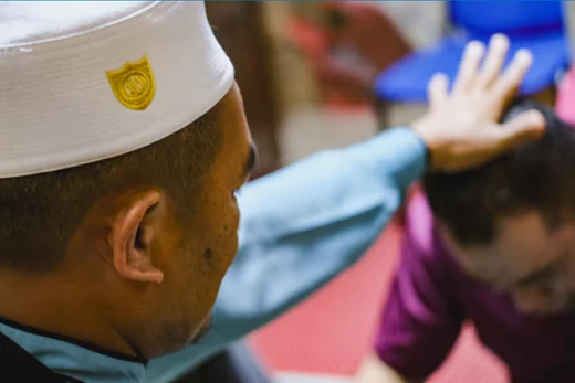 Abdul Manaf Jusoh (bên trái), chủ tịch Trung tâm Điều trị Hồi giáo Darussalam ở Bangi, đang thực hiện nghi lễ cho một bệnh nhân. Ảnh: Nikkei Asia.