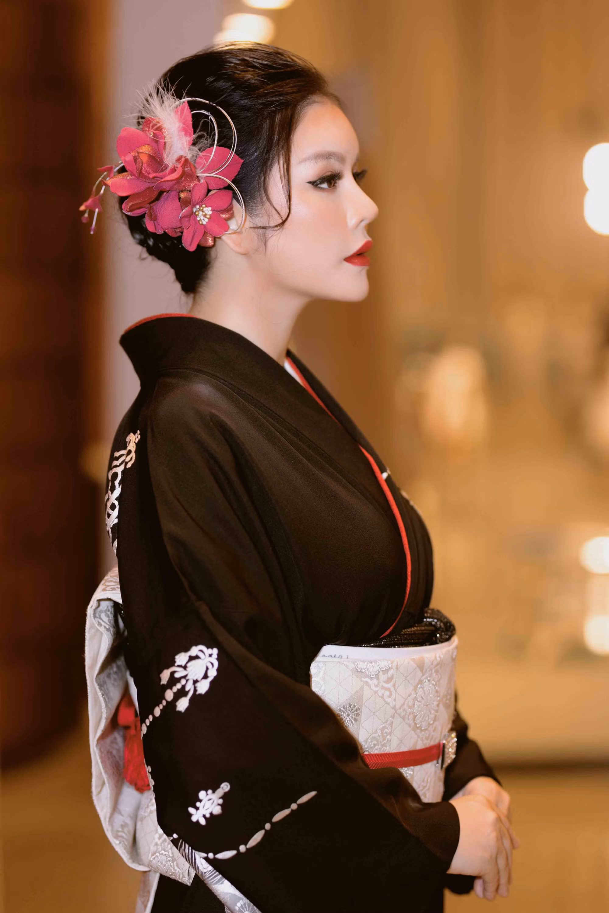 Tóc búi cao cổ điển, phù hợp nhất để tôn lên khuôn mặt và phần cổ, phụ kiện hoa cài tóc nhẹ nhàng.