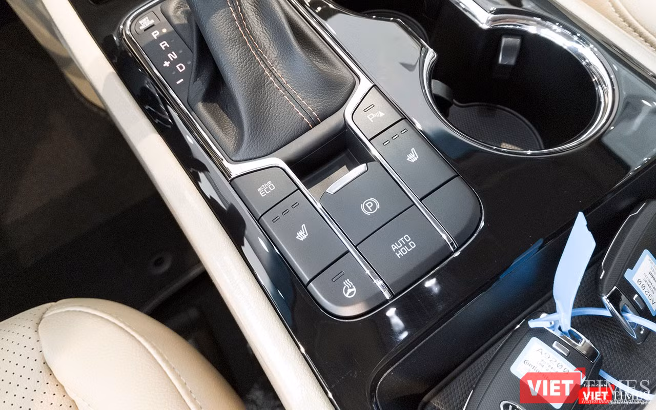 Một điểm nổi bật trong không gian nội thất của Kia Sedona 2018 còn là sự xuất hiện của phanh tay điện tử thay thế cho dạng đạp chân của phiên bản cũ, nhằm nâng cao mức độ an toàn cho người sở hữu. Ngoài ra, xe còn được bổ sung thêm tính năng phanh tự động khi dừng đỗ Auto Hold.