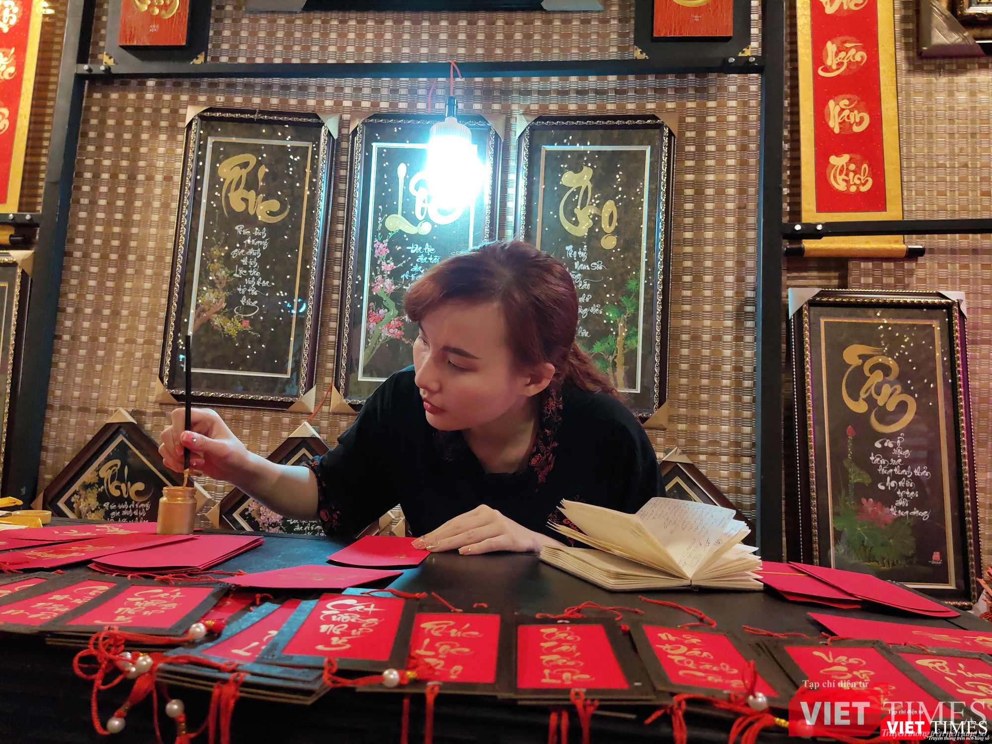 Nữ thư pháp gia còn rất trẻ miệt mài với những phong bao lì xì chúc xuân