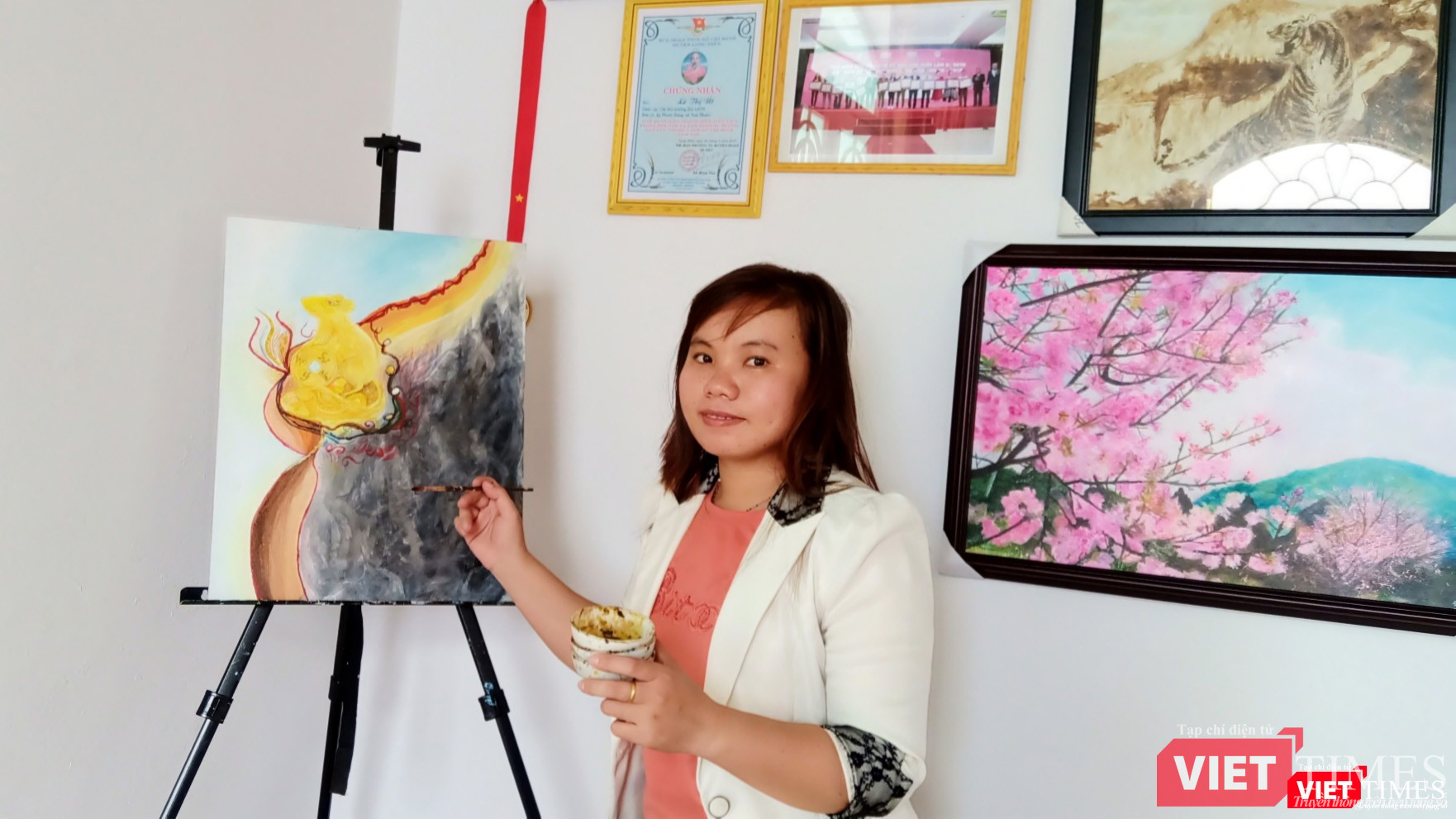 Họa sĩ Kim Út bên chùm tranh chuột đón Tết Canh Tý 