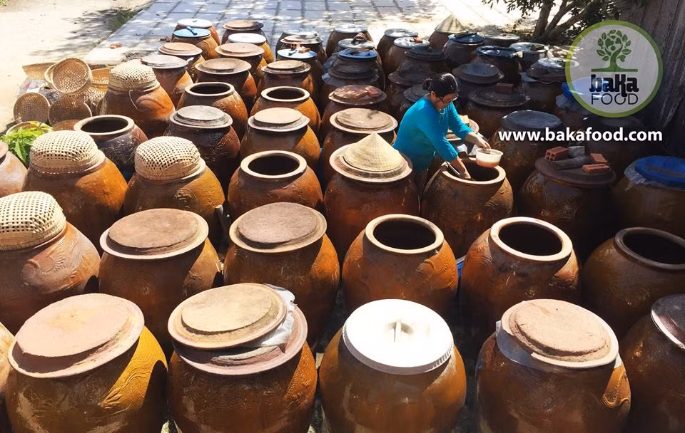 Bà Lục Thị Tường Vy bên những khạp da bò ủ nước mắm Cá Linh ở An Giang