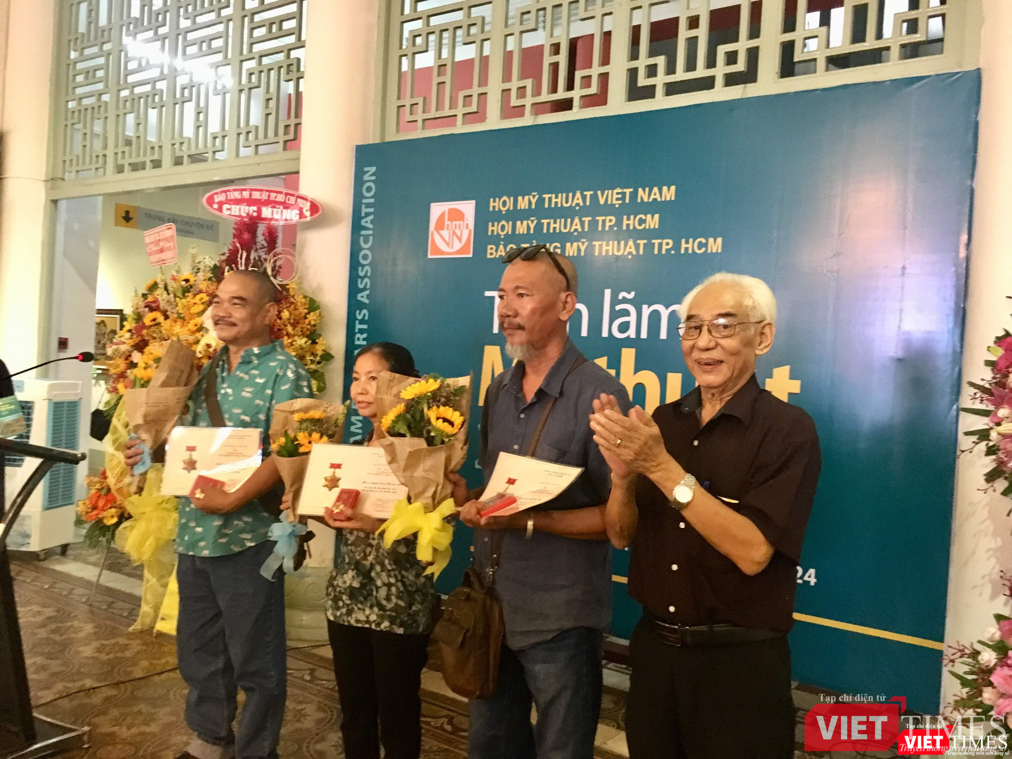 Họa sĩ Trần Khánh Chương (bên phải ảnh) tặng hoa cho các họa sĩ đoạt giải