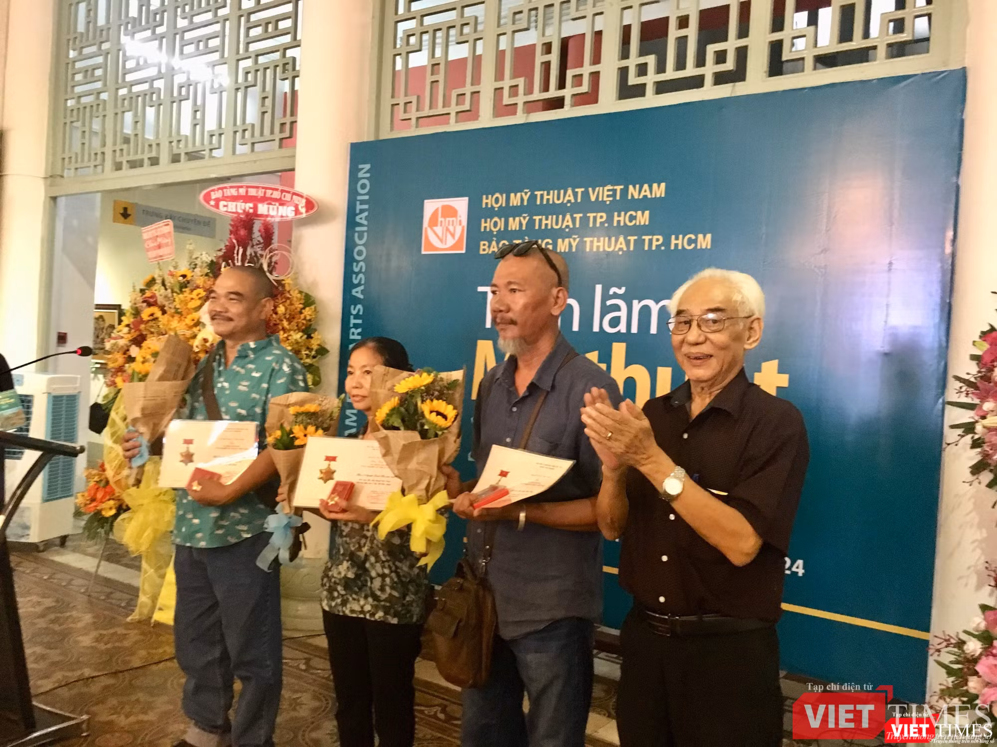 Họa sĩ Trần Khánh Chương (bên phải ảnh) tặng hoa cho các họa sĩ đoạt giải