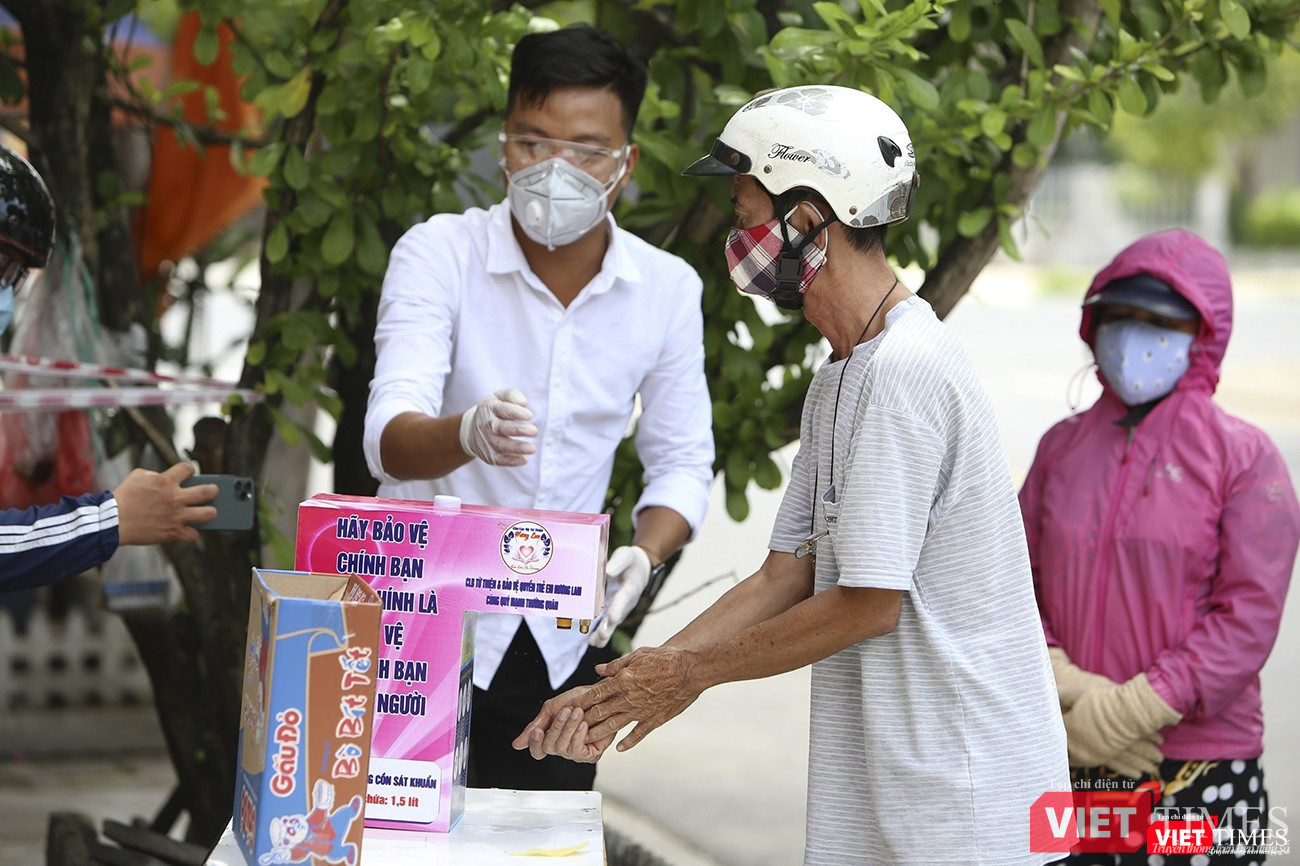 Người dân thực hiện rửa tay sát khuẩn trước khi mua hàng