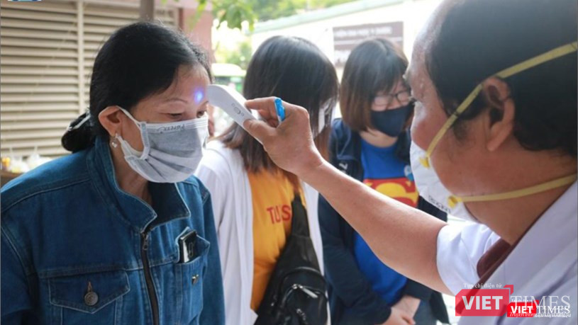 Mọi người được đo thân nhiệt bằng nhiệt kế điện tử