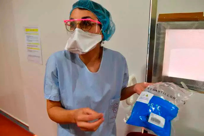 Một y tá của Bệnh viện Đại học Bordeaux mang mẫu được lấy từ bệnh nhân vào ngày 9/3. (Ảnh:AFP)