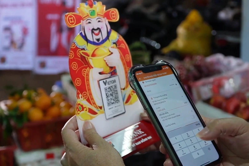 Tấm mã QR nhỏ bên sạp hàng cho thấy thanh toán số trở thành điều bình thường trong đời sống hằng ngày của người dân.