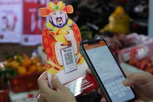 Tấm mã QR nhỏ bên sạp hàng cho thấy thanh toán số trở thành điều bình thường trong đời sống hằng ngày của người dân.
