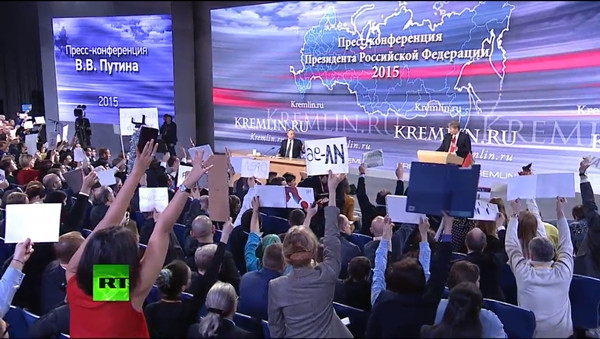 Phóng viên Nga và quốc tế tìm cách gây sự chú ý để được đặt câu hỏi cho Tổng thống Nga Vladimir Putin. Ảnh:RT.