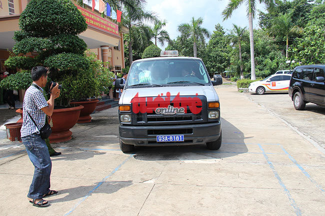 Chiếc xe chở nghi can đi nơi khác trong khi cuộc họp báo đang diễn ra. - Ảnh: Bá Sơn