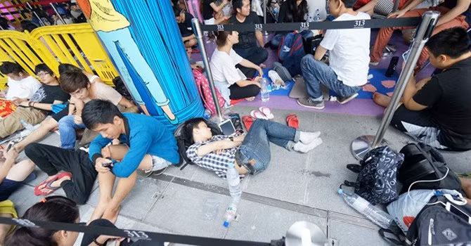 Nhiều du học sinh và nhân viên cửa hàng tập trung trước một điểm bán ở Singapore trong đợt bán iPhone 6 năm ngoái. Họ phải trải qua nhiều giờ ăn ngủ vạ vật để tranh suất mua iPhone. Ảnh: Duy Tí