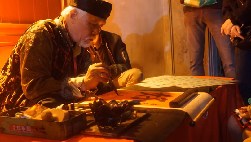 Quầy thư pháp ngay trước cổng Đền cũng rất đông khách.