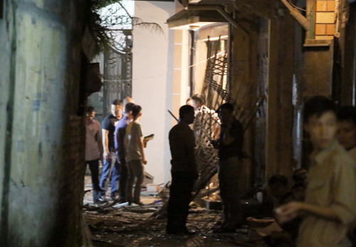 Cửa xếp sắt bật tung, biến dạng do sức ép vụ nổ. Ảnh: Bá Đô.