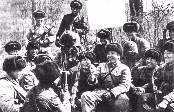 Lính Trung Quốc hả hê trước một chiếc mũ sắt lỗ chỗ vết đạn của biên phòng Liên Xô trong cuộc xung đột biên giới năm 1969