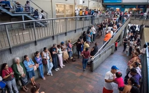 Người dân Venezuela xếp hàng chờ mua hàng hóa thiết yếu bên ngoài một siêu thị ở thủ đô Caracas.