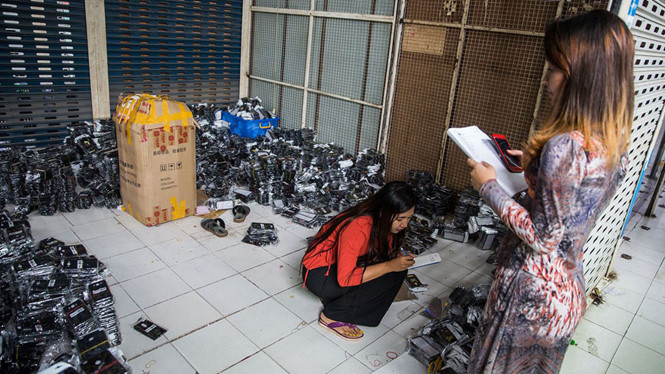 Nhân viên đang kiểm kê phụ kiện điện thoại di động tại một cửa hàng ở Yangon ẢNH: BLOOMBERG