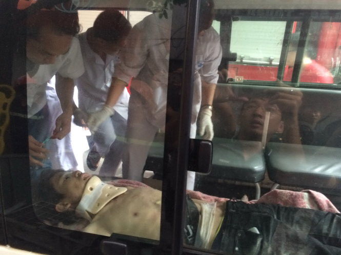 Một nạn nhân khoảng 20 tuổi mắc kẹt trong nhà sập được lực lượng cứu hộ đưa ra xe cấp cứu lúc 7g19 sáng 4-8 - Ảnh: Q.TR