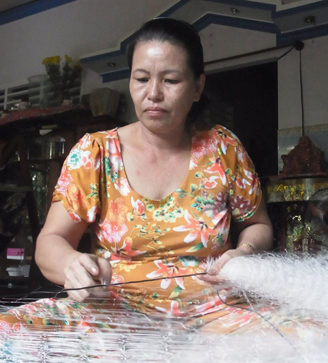 Số tiền tỉ từ bán đất không còn, bà Bạch Chí hằng ngày kiếm “bạc cắc” từ công việc kết chì cho lưới ghẹ - Ảnh: Tiến Trình
