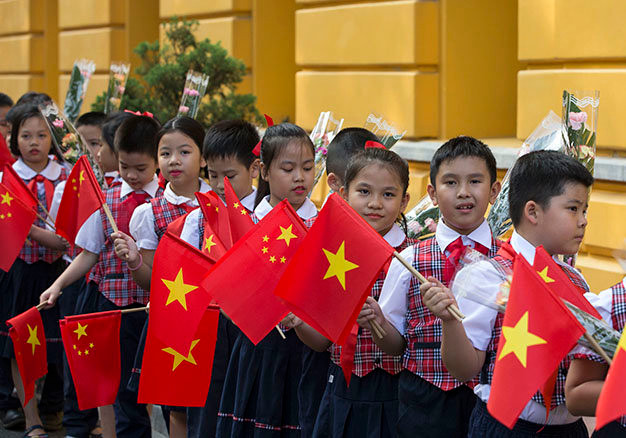 Các thiếu nhi vẫy cờ chào mừng tại lễ đón tiếp - Ảnh: Việt Dũng