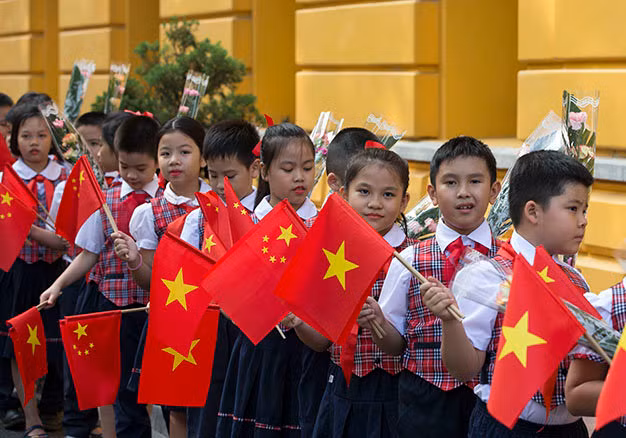 Các thiếu nhi vẫy cờ chào mừng tại lễ đón tiếp - Ảnh: Việt Dũng