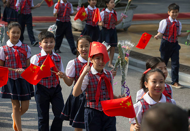 Các thiếu nhi vẫy cờ chào mừng tại lễ đón tiếp - Ảnh: Việt Dũng