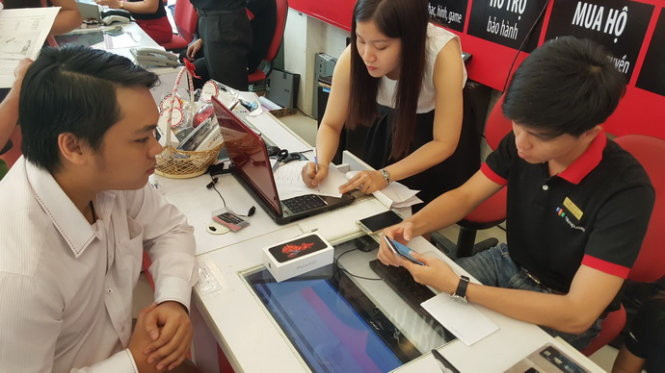 Một trong những khách hàng đầu tiên mua iPhone 6S chính hãng ngày 6-11 tại FPT Shop - Ảnh: T.Trực