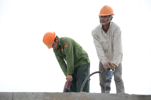 Các công nhân phá dỡ phần tum tòa nhà 8B Lê Trực. Ảnh: Giang Huy.