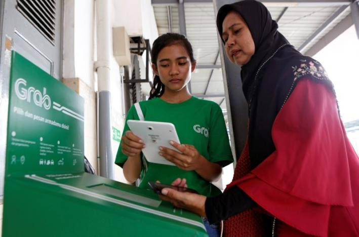 Nhân viên hãng Grab trợ giúp khách hàng gọi xe