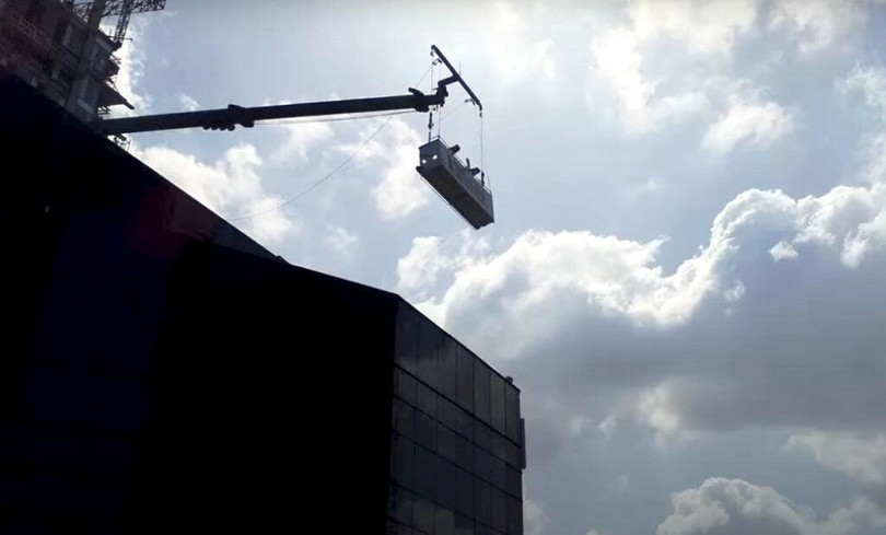 Các robot đi xuống từ bộ phận bảo trì tòa nhà - một thiết bị giống như cần cẩu - phổ biến cho tất cả các tòa nhà cao tầng. Ảnh Courtesy.