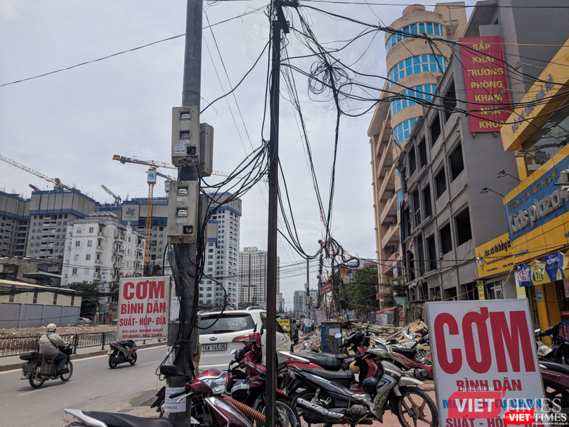 Dây điện, cáp viễn thông bó thành búi trước các cửa hàng.